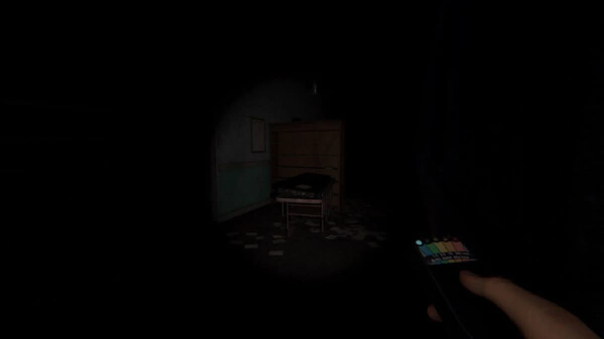 Phasmophobia player holding EMF reader in abandoned house