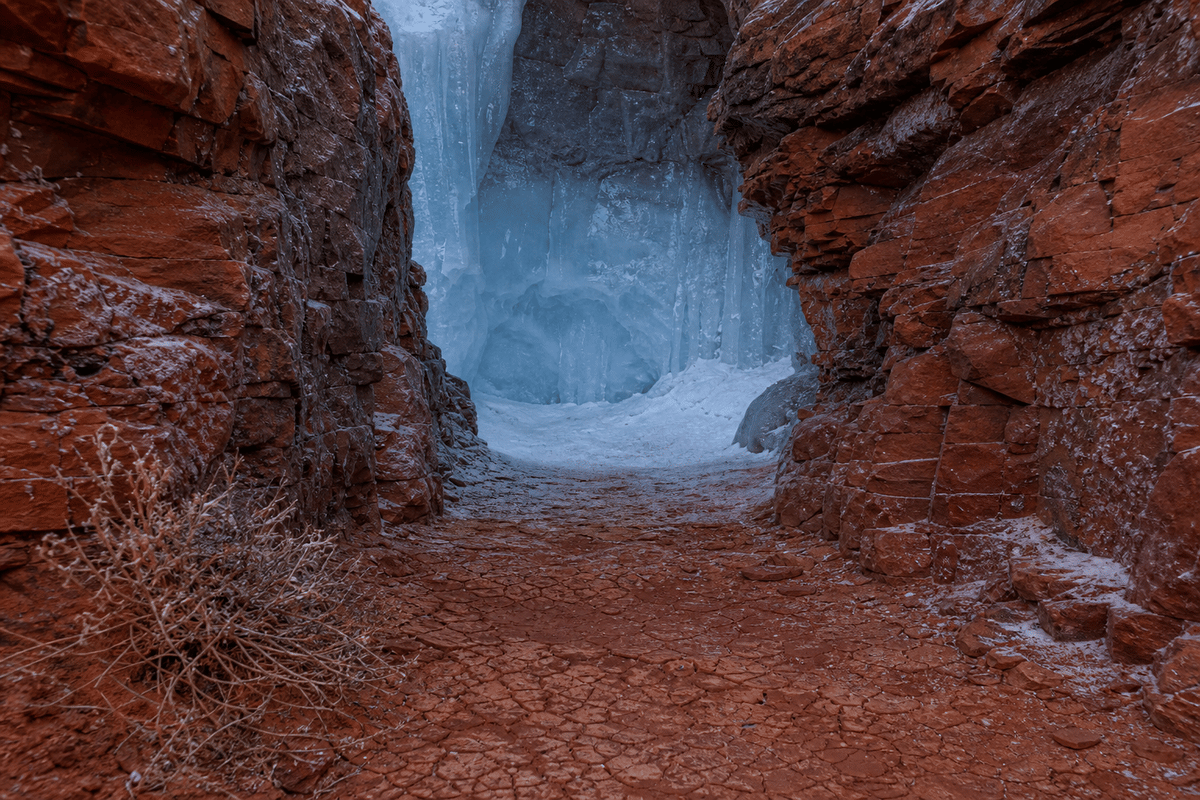 Ground-level traversal view guiding how one approaches the ice cradle from the desert terrain.